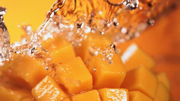 Slow Motion Shot of Water Splashing Through Mango Cube Slices