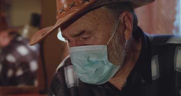 Portrait of Worried Ill Senior Man in Medical Mask Looks at Camera