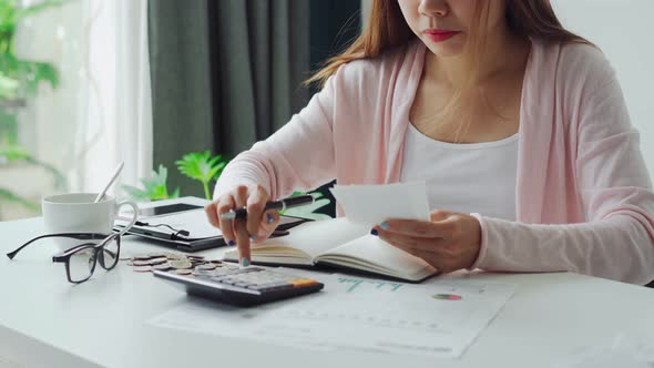 Stressed young woman calculating monthly home expenses