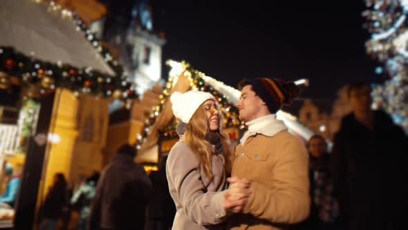 Beautiful Happy Couple Dancing in the European Street of Old Town at Christmas Fair