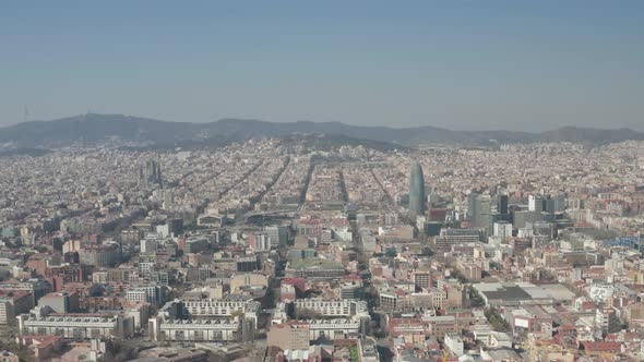 AERIAL: Barcelona Wide Drone Shot of City Towards Center with La Sagrada Familia and Torre Glories
