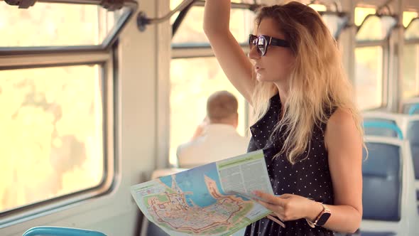 Female Traveler Riding In Train And Looking Town Plan On Navigation Map Journey. City Paper Map.