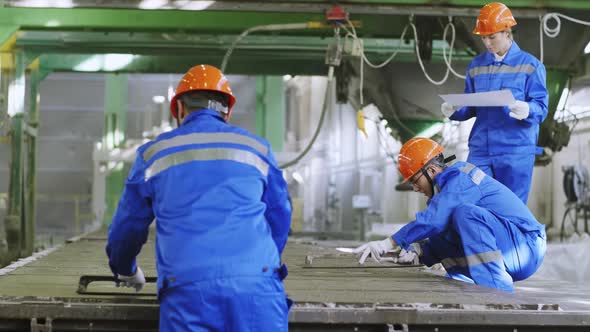 Crew foreman controlling factory workers