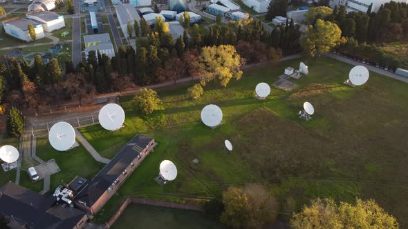 Aerial orbit shot of many satellites of research center connecting outdoors