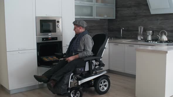 Man in Wheelchair Taking out Hot Cookies