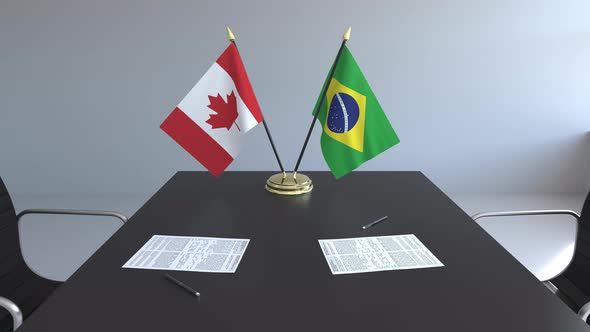 Flags of Canada and Brazil and Papers on the Table