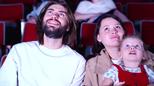 Friendly family watching a movie in the cinema