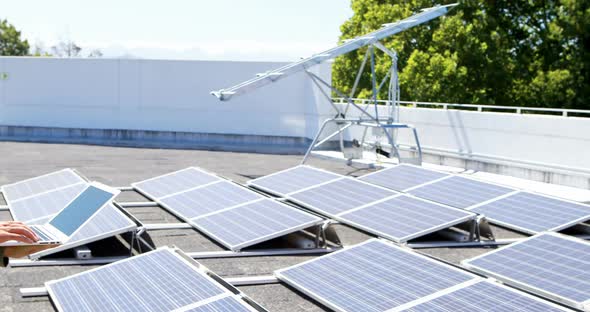 Male worker using laptop at solar station