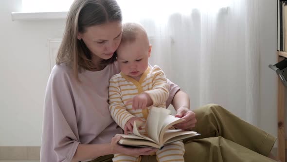 Mother and Baby Sonreading a Book in Bed Before Going to Sleep