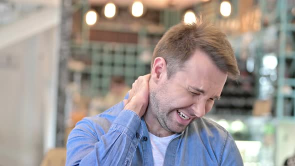 Portrait of Exhausted Casual Man with Neck Pain