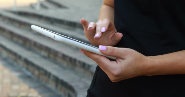 Businesswoman using digital tablet outside office building 4k