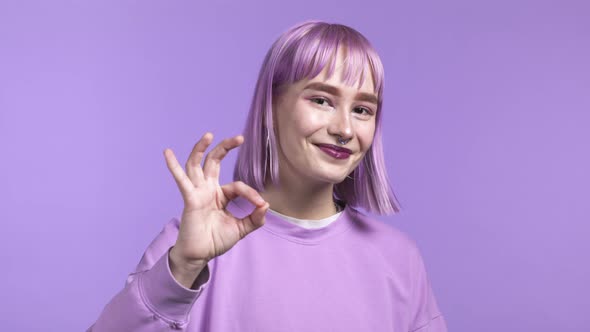 Young Woman Showing Ok Like Sign Over Violet Studio Background