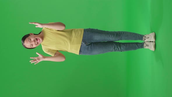 Full Body Of A Young Asian Kid Girl Opening His Eyes With Palms In The Green Screen Studio