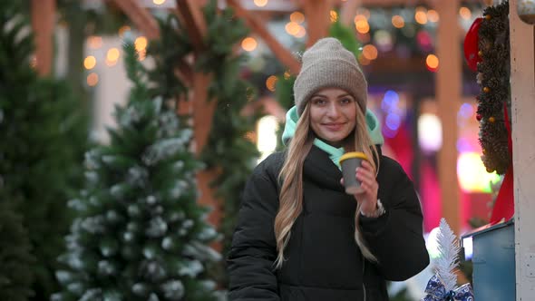 Young happy girl enjoying winter holidays at Christmas market