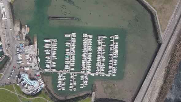 Motor Boat and Sailboats In Howth Harbor In Dublin County, Ireland - aerial drone, top down