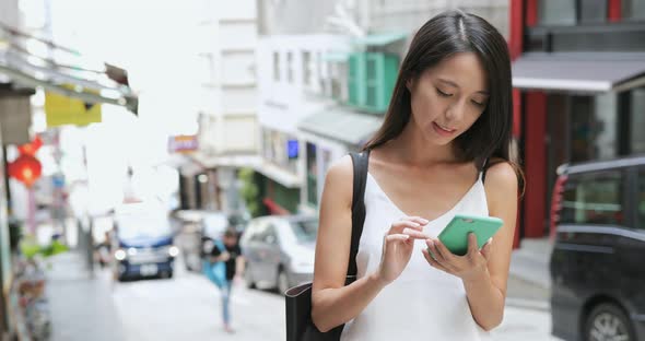 Woman use of mobile phone in city 