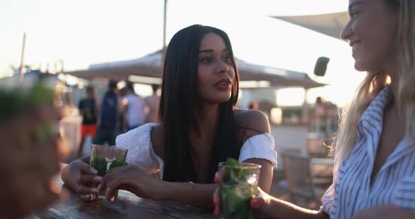 Happy multiracial girls having fun drinking mojitos at beach party outdoor