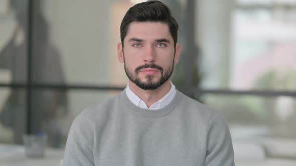 Portrait of Serious Young Man Looking at the Camera