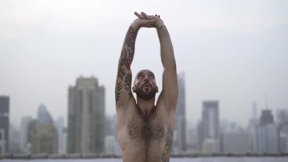 Male Standing Vertical Shirtless As Keep His Gaze Up With His Arms