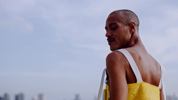 Man In Yellow Clubwear Spinning Around On City Rooftop