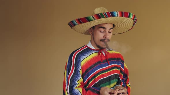 Young Mexican In Multicolored Poncho And Hat