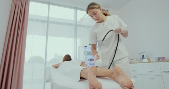 Woman is Receiving the Vacuum Massage Her Legs and Buttocks with Tool While Lying in the Spa Salon