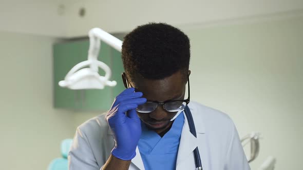 Young African Doctor Wearing Glasses in the Hospital Office.