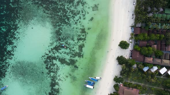 Top down of white sand beach and coral reef in Koh Lipe Thailand, aerial