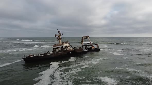 Drone footage of an old rusty sunken ship with lots of seagulls on it