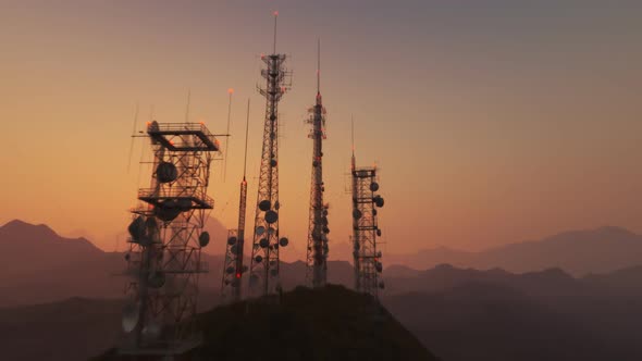 Antenna complex on a hill flythrough. Tall masts or towers during sunset.