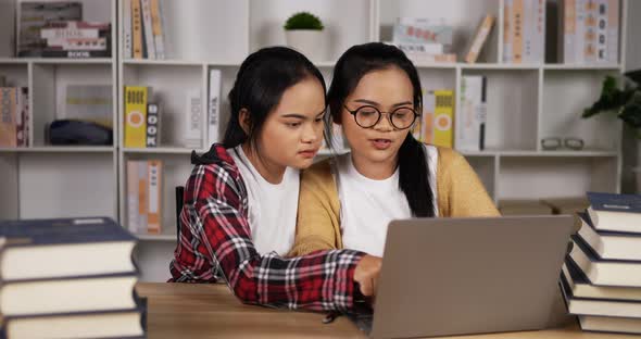 Twin asian girls using laptop to learning online