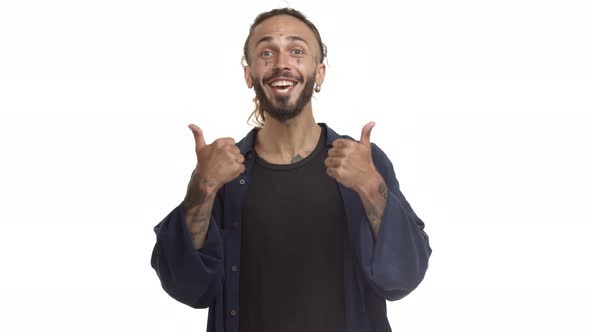 Cheerful Caucasian Man with Beard and Tattoos on Face Showing Thumbsup in Approval Like Something