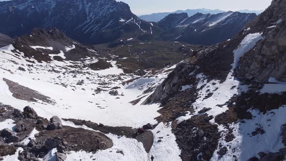 Anonymous travelers walking on Picos de Europa mountains covered with snow alt