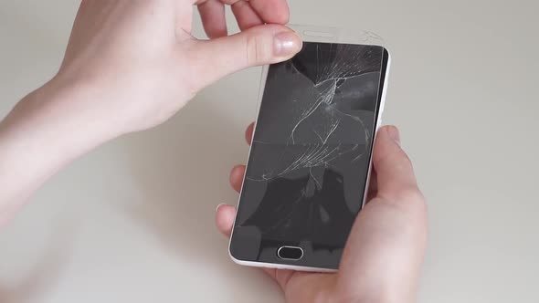 Removes the Protective Glass From the Smartphone