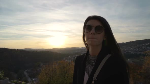 Beautiful Girl Stares at Sunset Clouds Over Scenic Hills in Veliko Tarnovo, Bulgaria