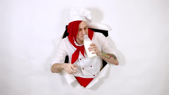 Young Man Dressed As Chef Drinking Milk