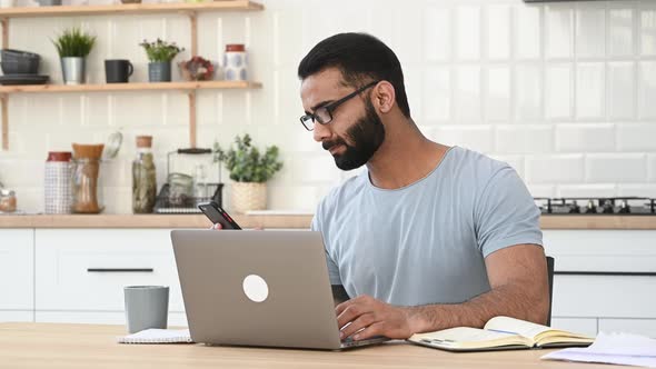 Busy Successful Indian Man IT Specialist or Freelancer Sitting at Work Desk at Home Having a Nice