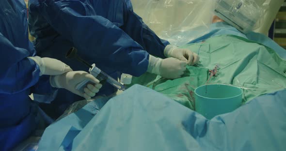 Surgeons preforming a cardiac catheterization in an operating room in a hospital