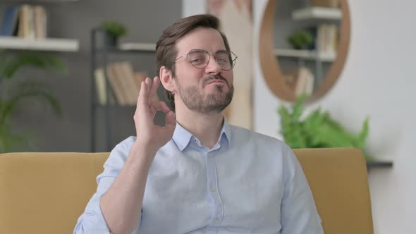 Portrait of Young Man Showing OK Sign at Home