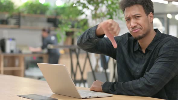 Thumbs Down Sign By African American Man with Laptop