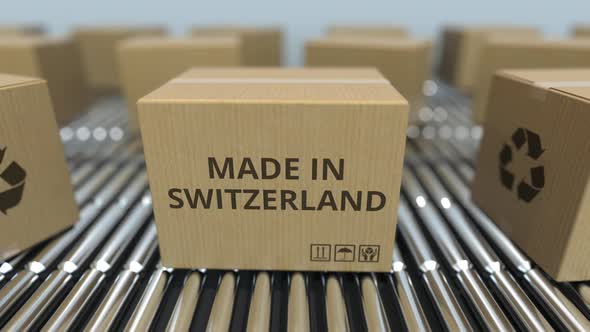 Boxes with MADE IN SWITZERLAND Text on Roller Conveyor