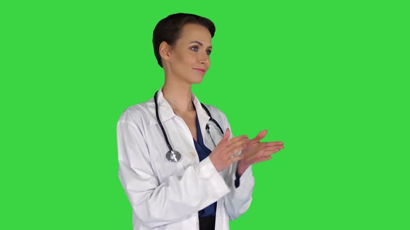 Doctor Woman Wearing Medical Coat Over Isolated Clapping and Applauding on a Green Screen, Chroma