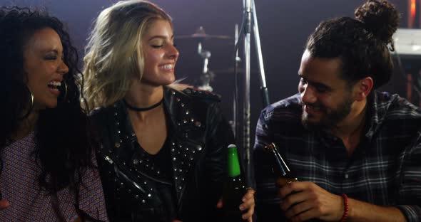 Group of friends toasting beer bottles at a concert 4k