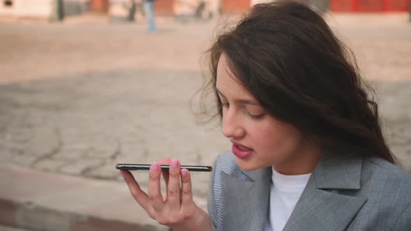 Portrait of Businesswoman Talking Voice Message on a Smartphone on the Street