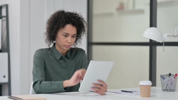 Successful African Woman Celebrating on Tablet at Work