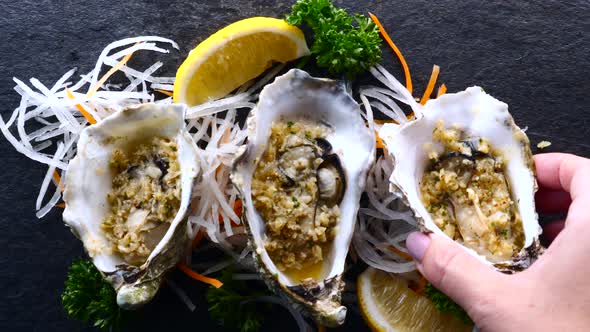 Woman Hand Takes Oyster Off Table in Restaurant