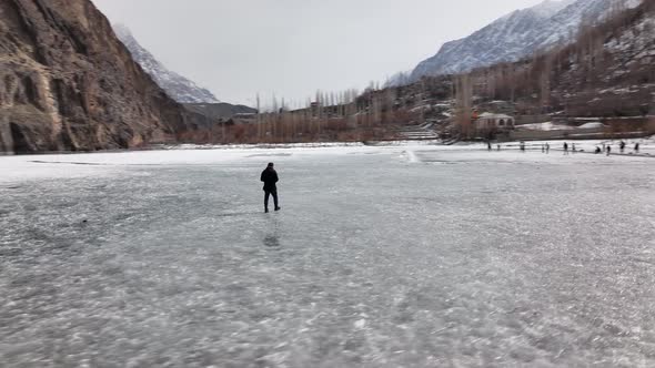 Cinematic. A teenager walks on ice in a blizzard at khalti lake  . Bad weather conditions, snowfall.