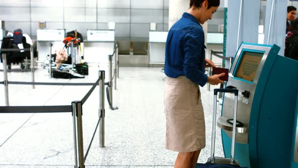 Female commuters using airline ticket machine