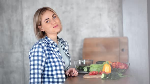 Medium Closeup Portrait of Beautiful Young Vegan Woman Eating Vegetables During Cooking Meal