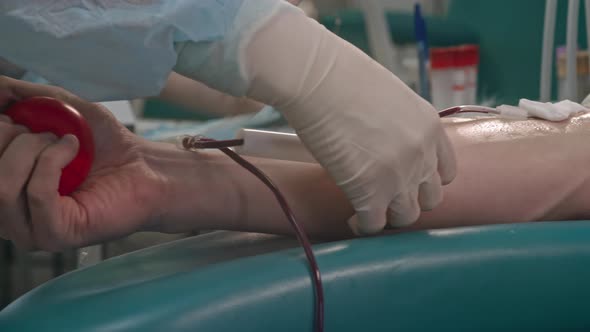 Nurse Taping Plastic Tubes to Donor Arm